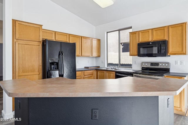 kitchen featuring wood finished floors, a sink, lofted ceiling, and black appliances