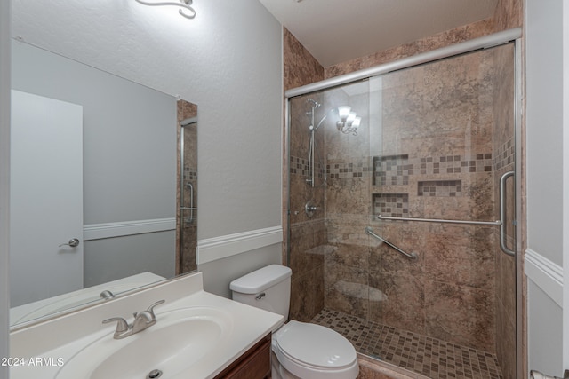 bathroom featuring walk in shower, vanity, and toilet