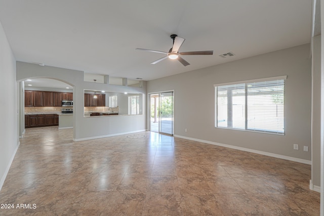 unfurnished living room with ceiling fan