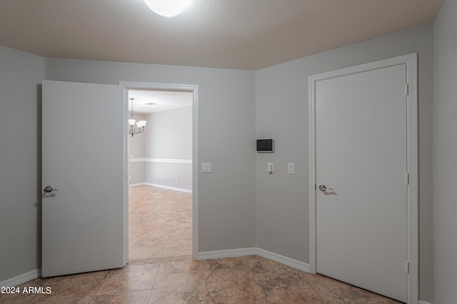 interior space with light tile patterned flooring and a notable chandelier