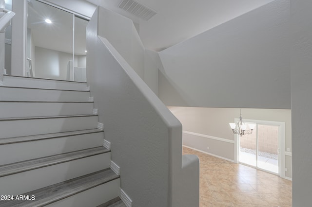 stairs featuring an inviting chandelier