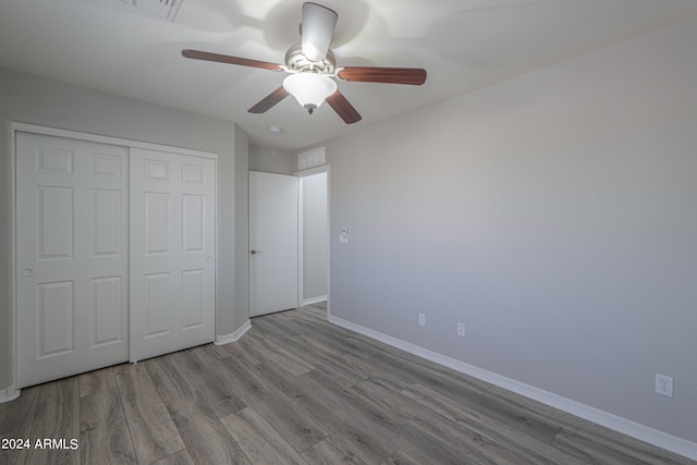 unfurnished bedroom featuring a closet, light hardwood / wood-style flooring, and ceiling fan