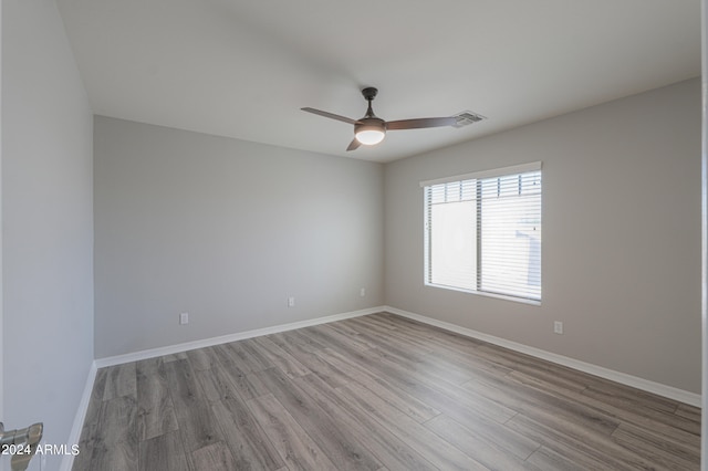 empty room with ceiling fan and light hardwood / wood-style flooring