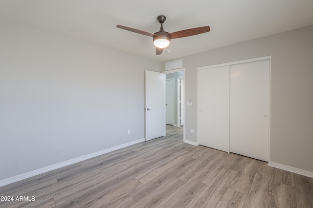 unfurnished bedroom featuring light wood-type flooring, ceiling fan, and a closet