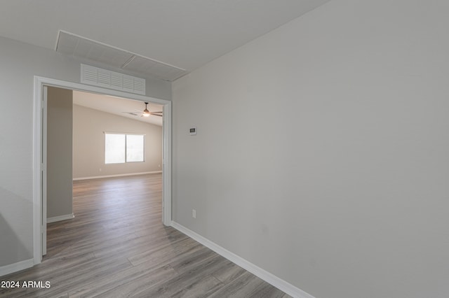 hallway featuring lofted ceiling and light hardwood / wood-style floors