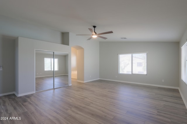 unfurnished bedroom with wood-type flooring, multiple windows, and ceiling fan