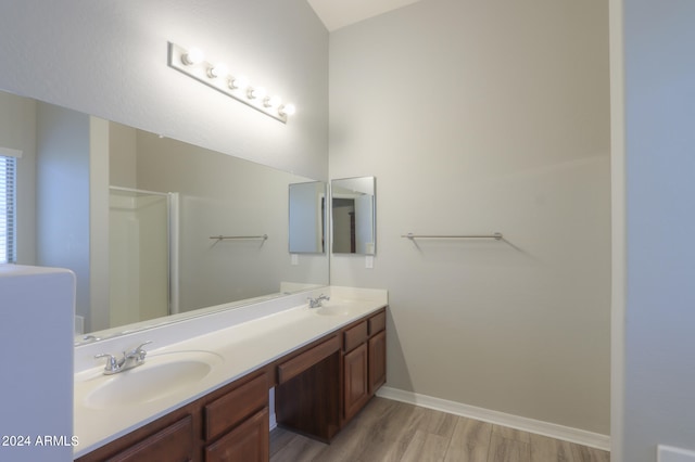 bathroom with hardwood / wood-style flooring, an enclosed shower, and vanity