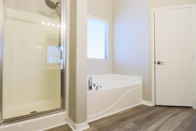 bathroom featuring hardwood / wood-style flooring and separate shower and tub