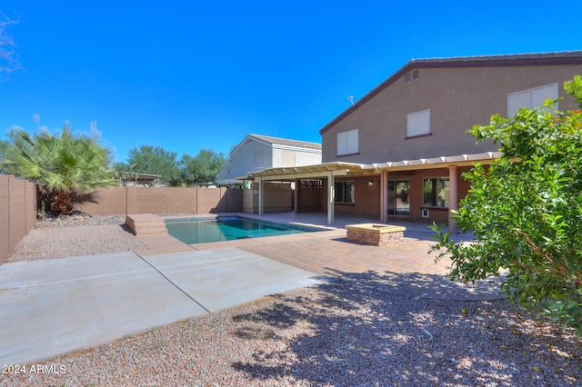 view of swimming pool with a fire pit and a patio