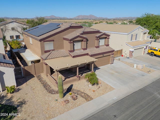 view of front of home featuring a mountain view, a garage, and solar panels