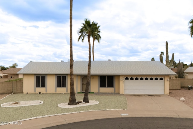 ranch-style home featuring concrete driveway, fence, and a garage