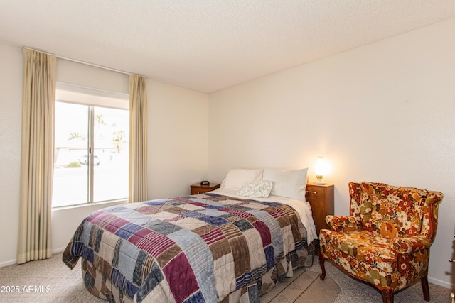 bedroom featuring light carpet, a textured ceiling, and baseboards