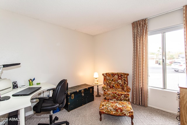 home office featuring a wealth of natural light, baseboards, and light carpet