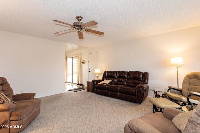 living area featuring a textured ceiling, carpet, and ceiling fan