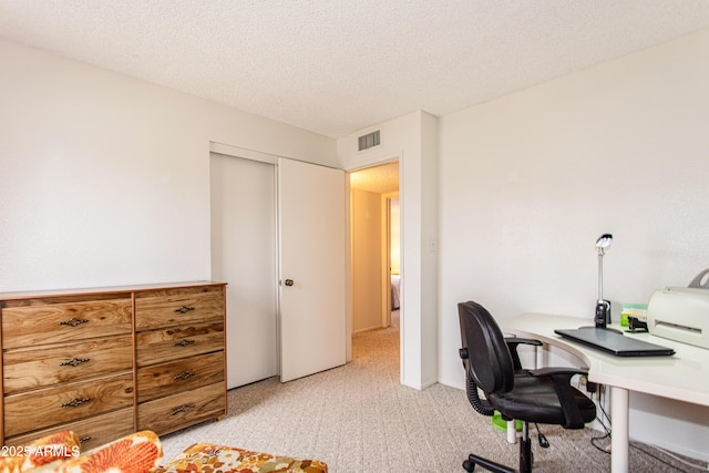 office with light colored carpet, visible vents, and a textured ceiling