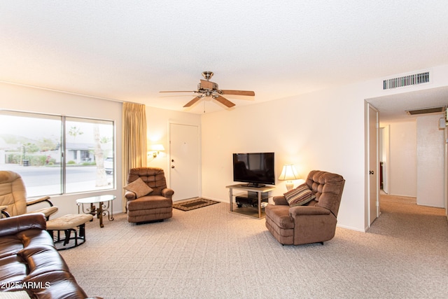 carpeted living area with visible vents, a textured ceiling, baseboards, and ceiling fan