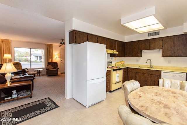 kitchen featuring visible vents, under cabinet range hood, dark brown cabinetry, white appliances, and a sink