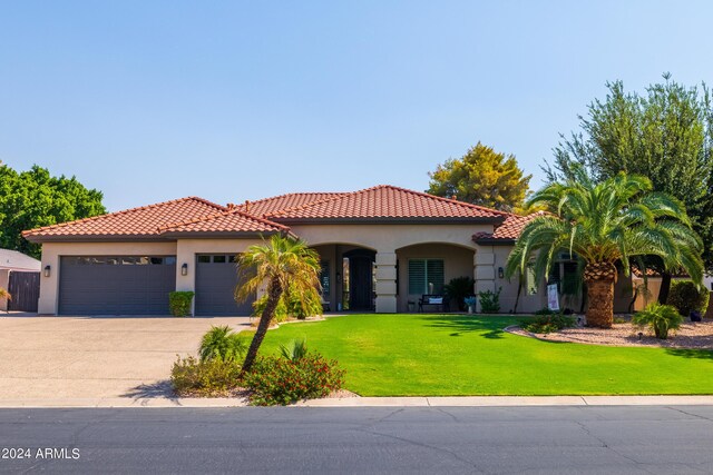 mediterranean / spanish-style house featuring a garage and a front yard