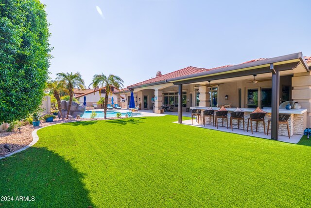 view of yard with a bar, ceiling fan, and a patio