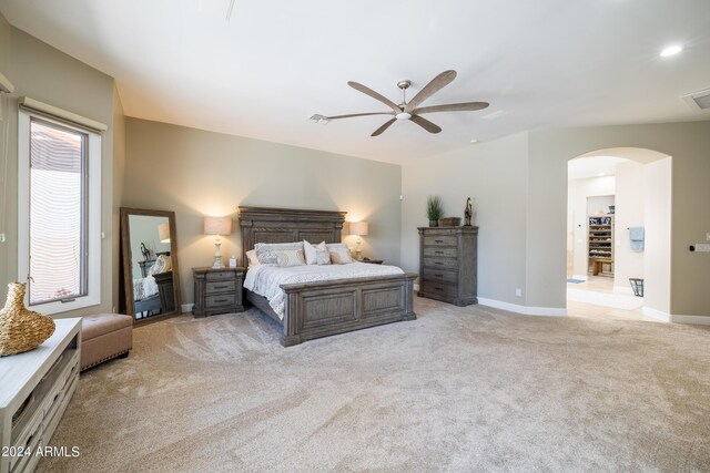 bedroom featuring multiple windows, light colored carpet, and ceiling fan