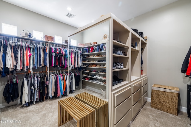 spacious closet featuring light colored carpet