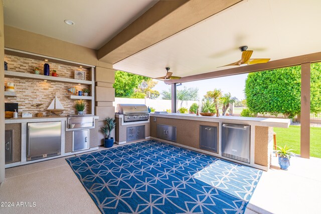 view of patio with an outdoor kitchen, ceiling fan, and a grill