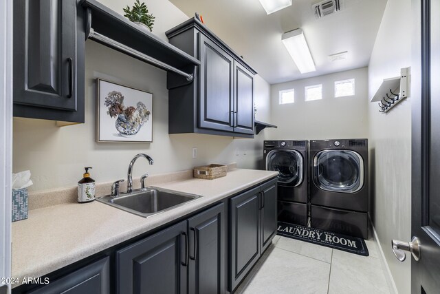 clothes washing area with light tile patterned floors, cabinets, sink, and washing machine and dryer