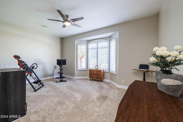 exercise room featuring ceiling fan and light carpet