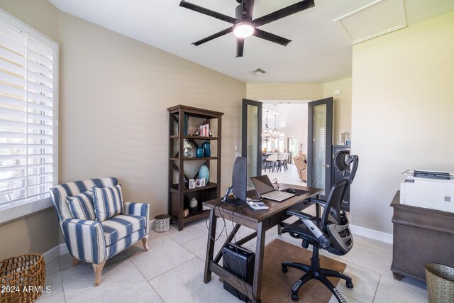 tiled office space featuring ceiling fan with notable chandelier