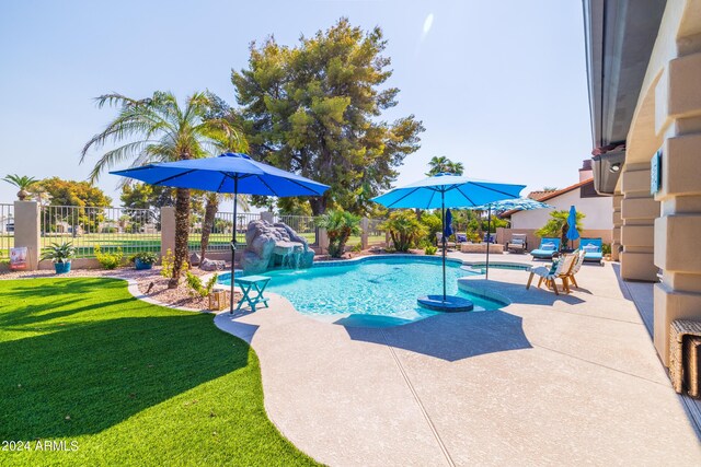 view of swimming pool with a patio area, a lawn, and pool water feature