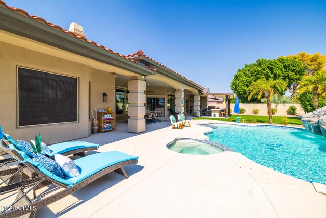 view of swimming pool featuring a patio area and an in ground hot tub