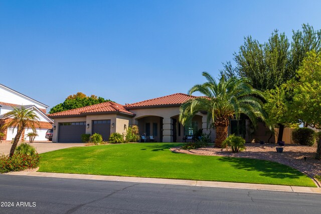 mediterranean / spanish-style house with a garage and a front lawn