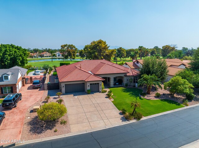 mediterranean / spanish-style home with a front yard and a garage