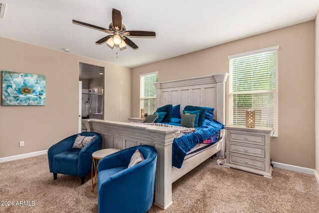 carpeted bedroom with ceiling fan and ensuite bath