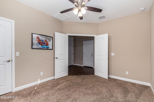 unfurnished bedroom with dark colored carpet and ceiling fan