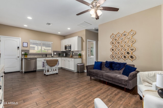 living room featuring sink, dark hardwood / wood-style floors, and ceiling fan