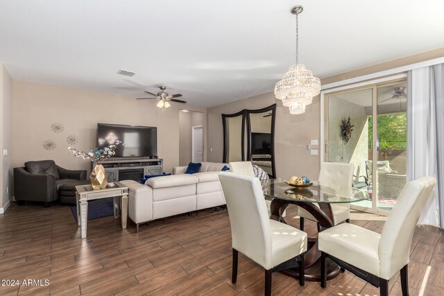 dining area with ceiling fan with notable chandelier and dark hardwood / wood-style floors