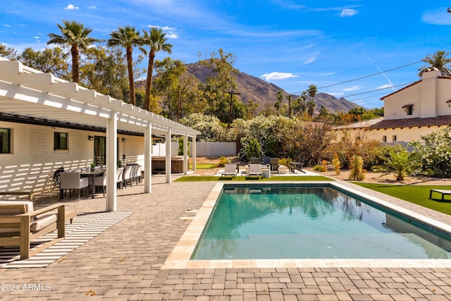 pool with a mountain view, a pergola, outdoor dining space, fence, and a patio