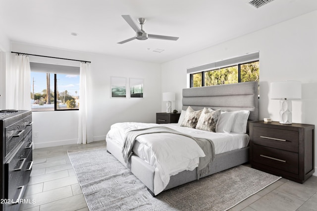 bedroom featuring a ceiling fan, baseboards, multiple windows, and visible vents