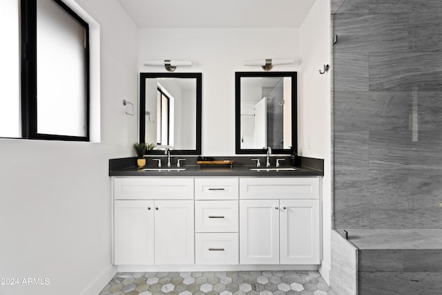 bathroom with a tile shower and vanity