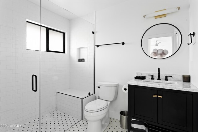 bathroom featuring vanity, a stall shower, baseboards, and toilet