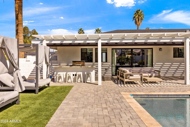 back of property with outdoor lounge area, a pergola, and a patio area