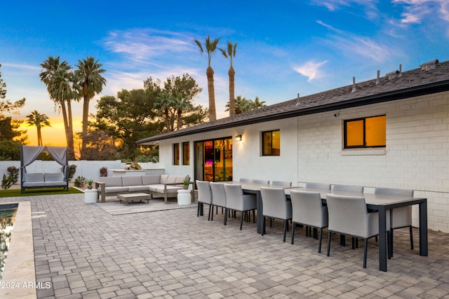 patio terrace at dusk featuring an outdoor living space