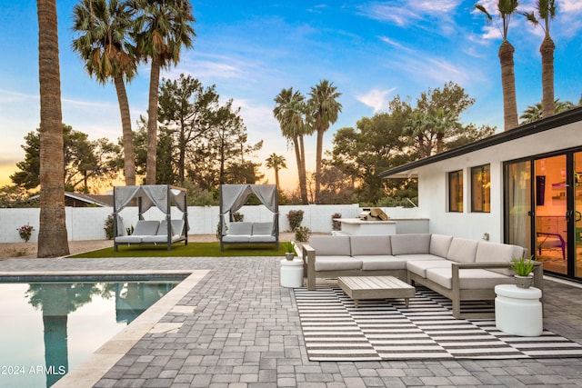 pool at dusk featuring outdoor lounge area and a patio area