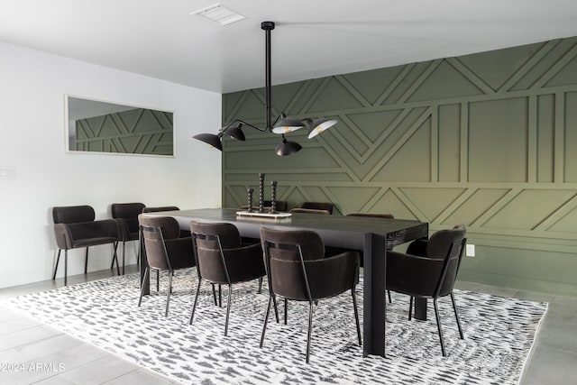 dining room featuring a decorative wall, an accent wall, baseboards, and visible vents