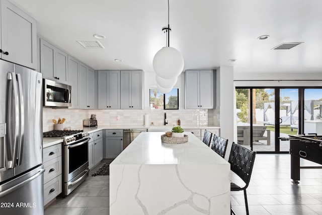 kitchen with gray cabinets, a healthy amount of sunlight, visible vents, and stainless steel appliances