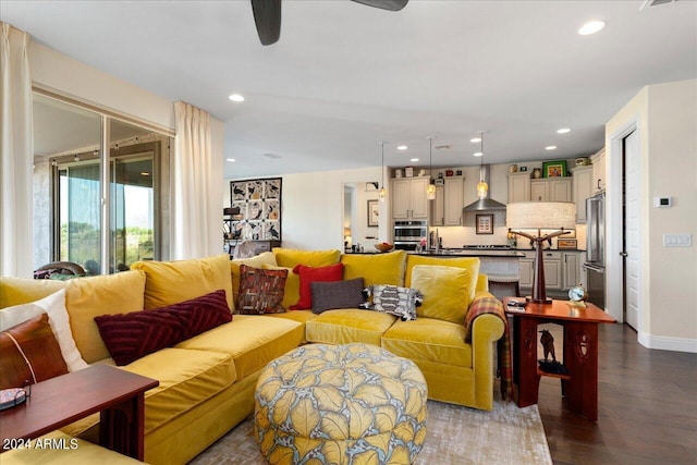 living room with dark hardwood / wood-style flooring and ceiling fan