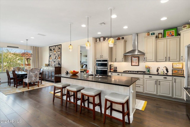 kitchen with pendant lighting, a kitchen breakfast bar, and wall chimney exhaust hood