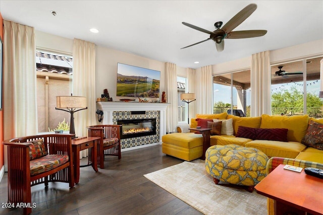 living room featuring ceiling fan, a fireplace, and dark hardwood / wood-style floors