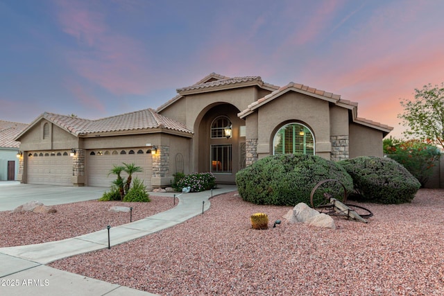 2058 E Marlene Dr, Gilbert, AZ 85296 - mediterranean / spanish home featuring stucco siding, an attached garage, driveway, a tiled roof, and stone siding